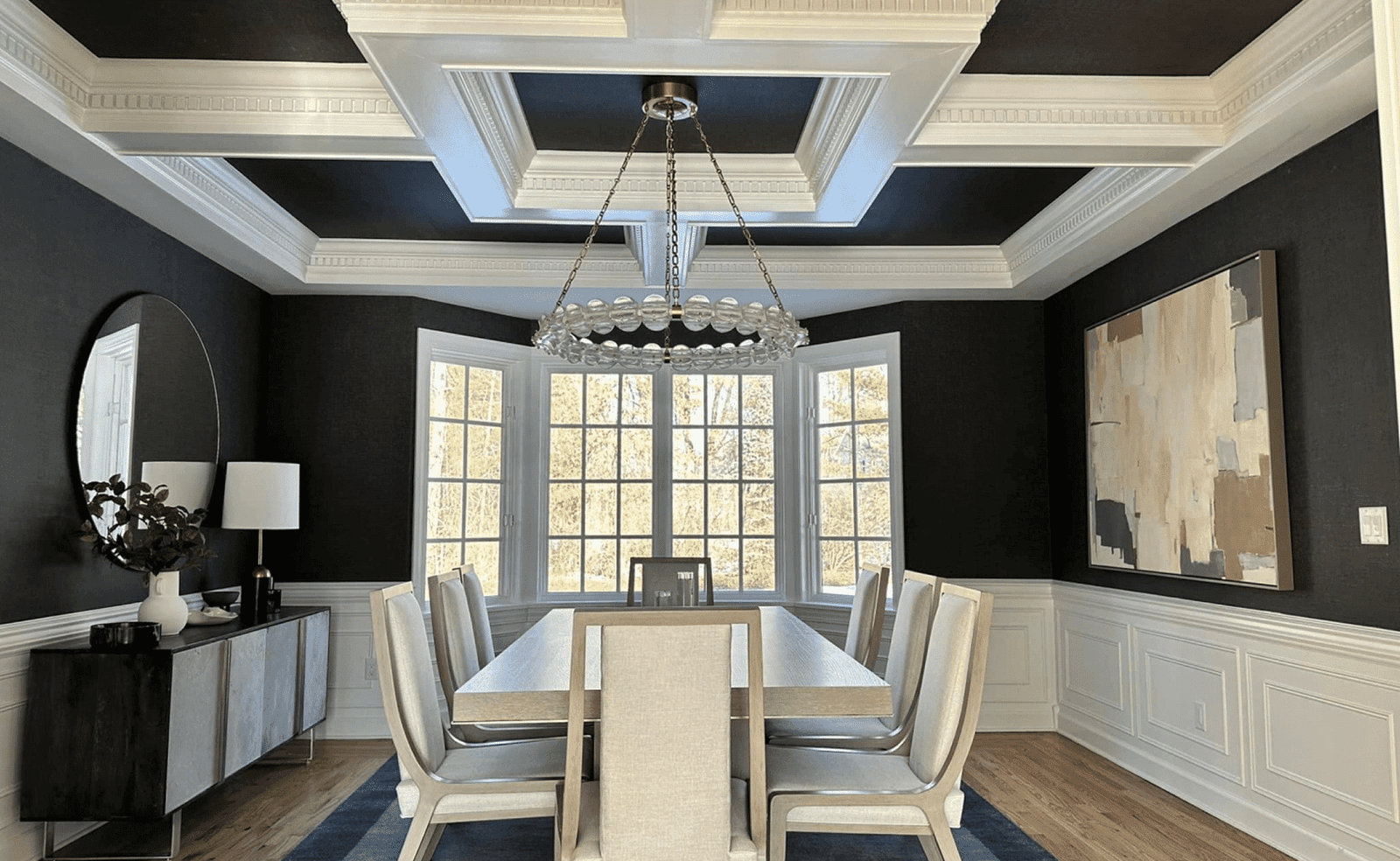 Sterling Heights, MI 11 Dining room with table, eight chairs, coffered ceiling, large window, chandelier, art, sideboard.