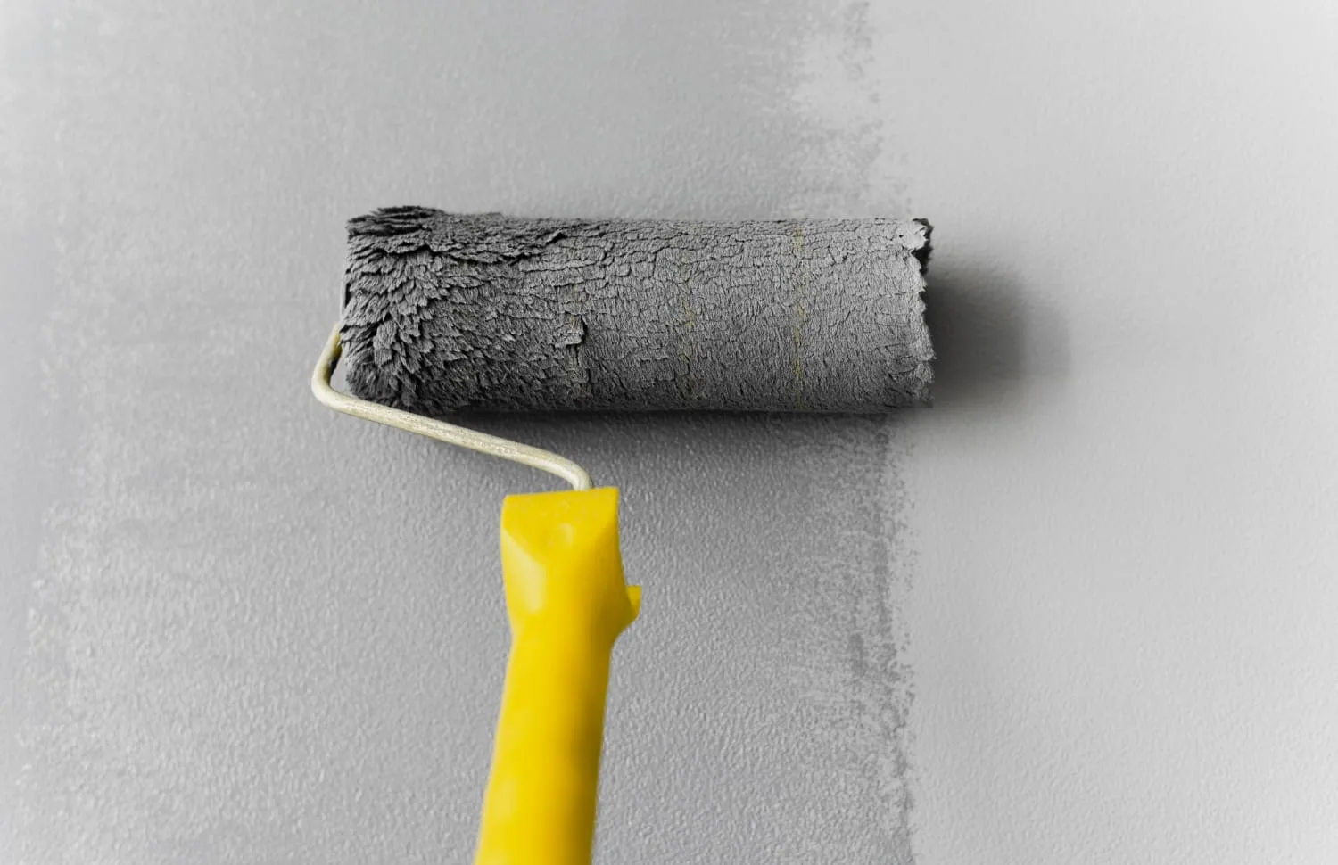 a paint roller with a yellow handle