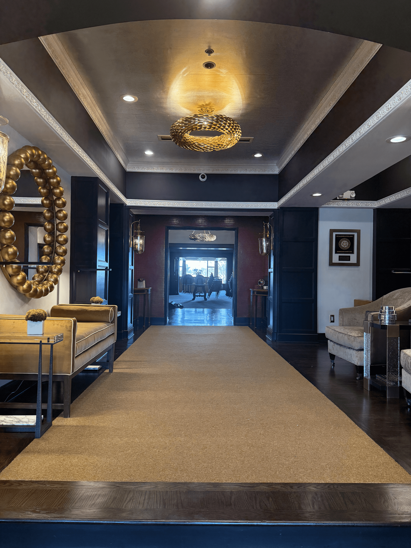 a hallway with a chandelier and couches