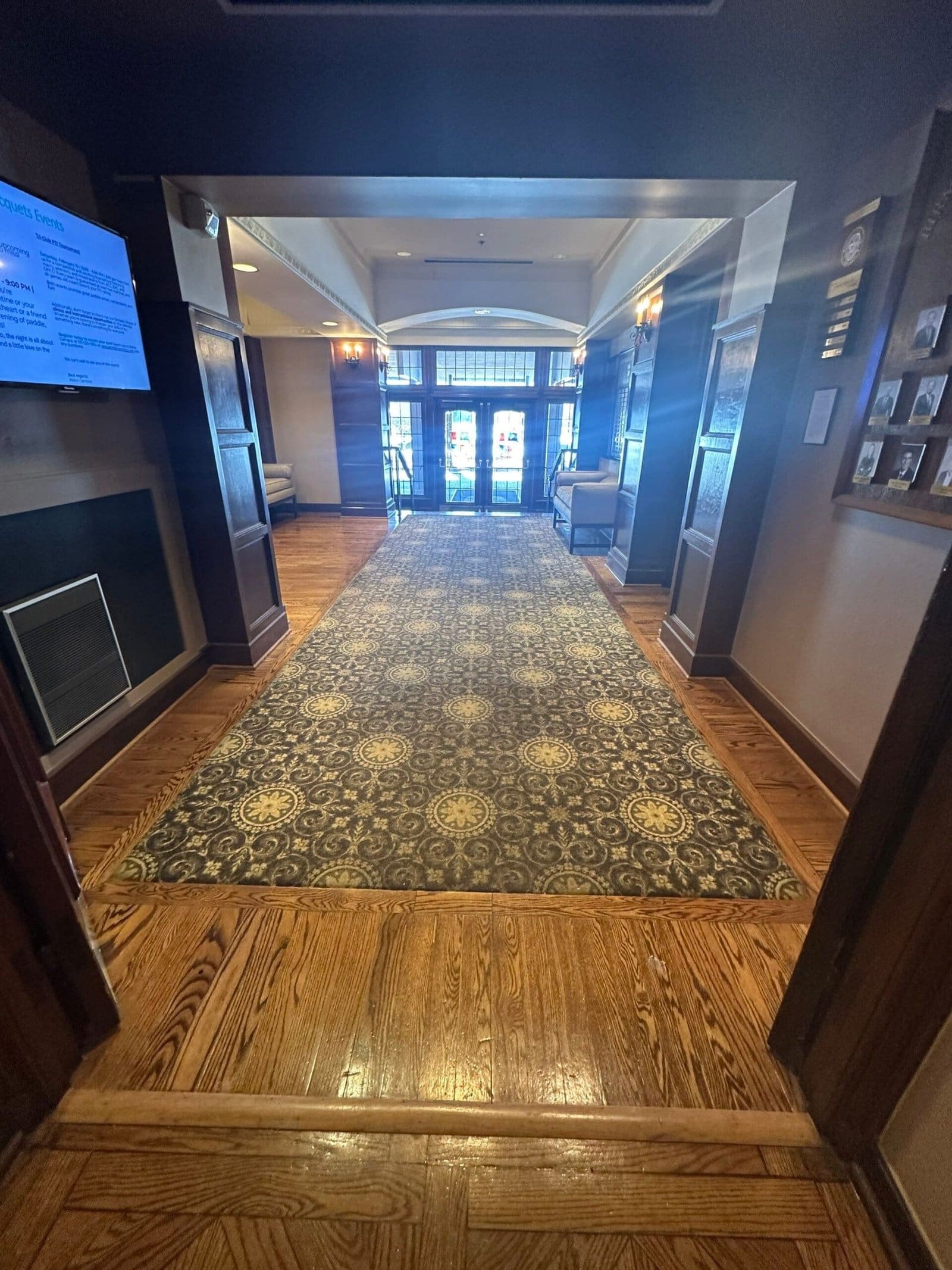 a hallway with a carpet and a television