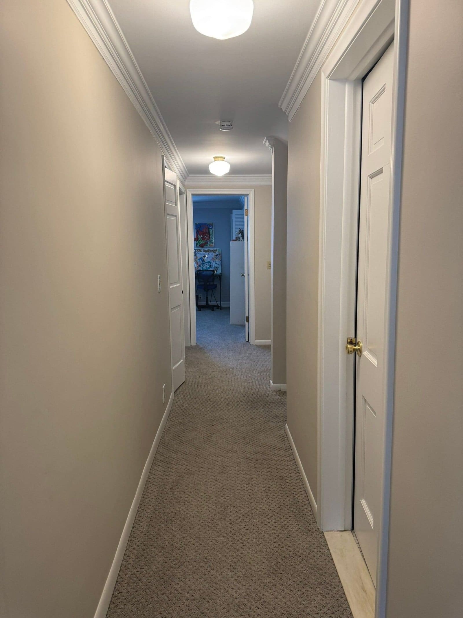 a hallway with white walls and carpet